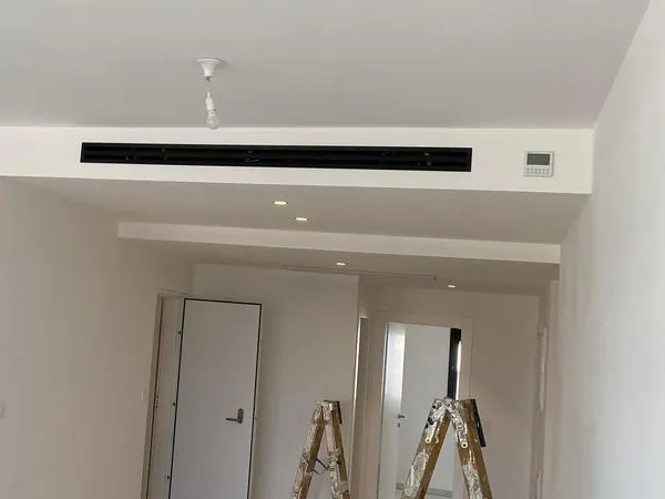 דירה בהתקנה עם מפזר מיזוג קווי בתקרה ומבט למסדרון